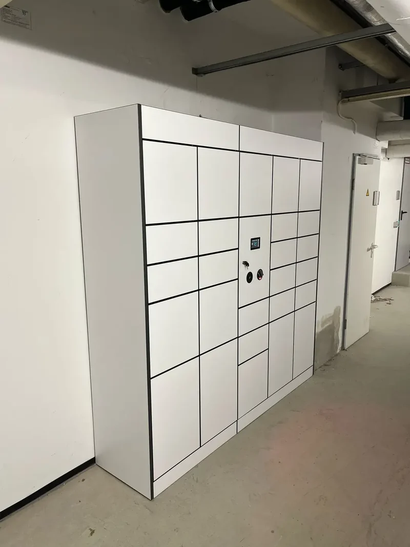 White parcel lockers installed beside a corridor