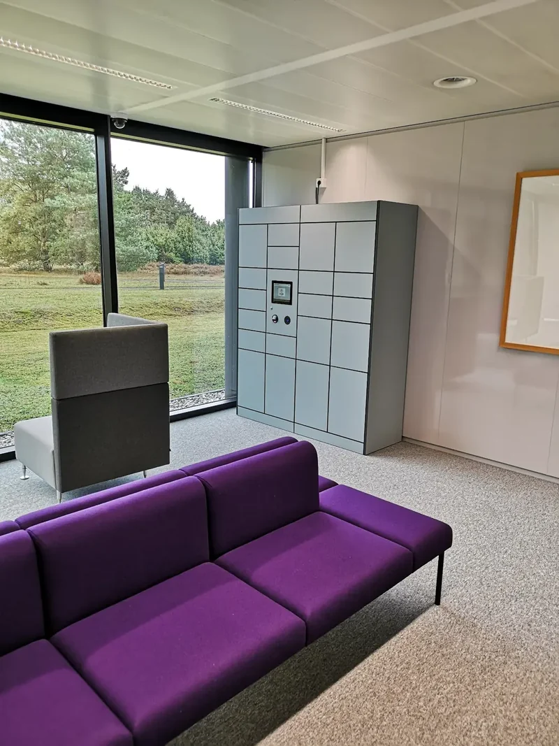 Compact grey parcel lockers beside lobby seating
