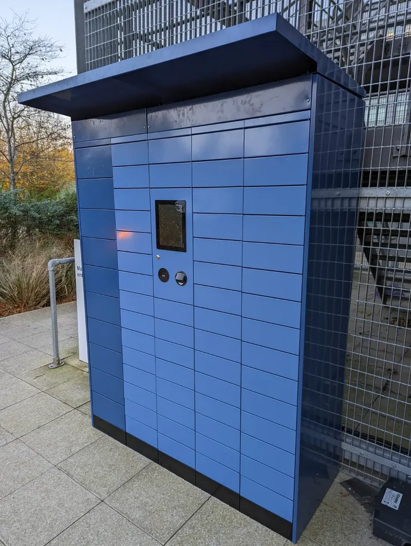 Blue outdoor parcel lockers with an overhead canopy