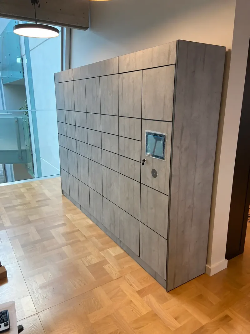 Wood-effect parcel locker bank beside a glazed entrance